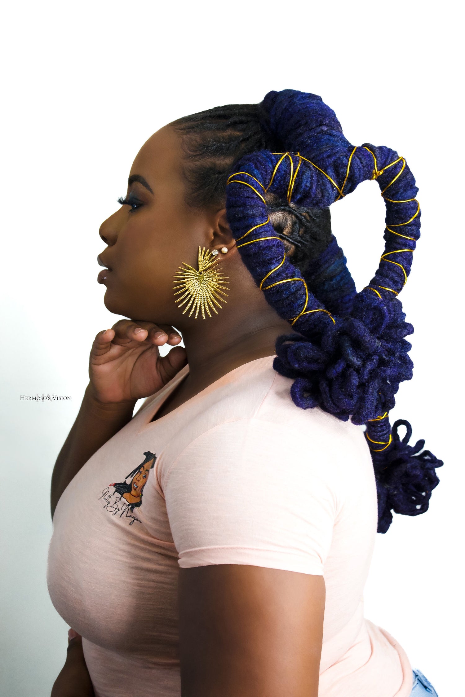Black Woman with blue locs styled in heart shapes