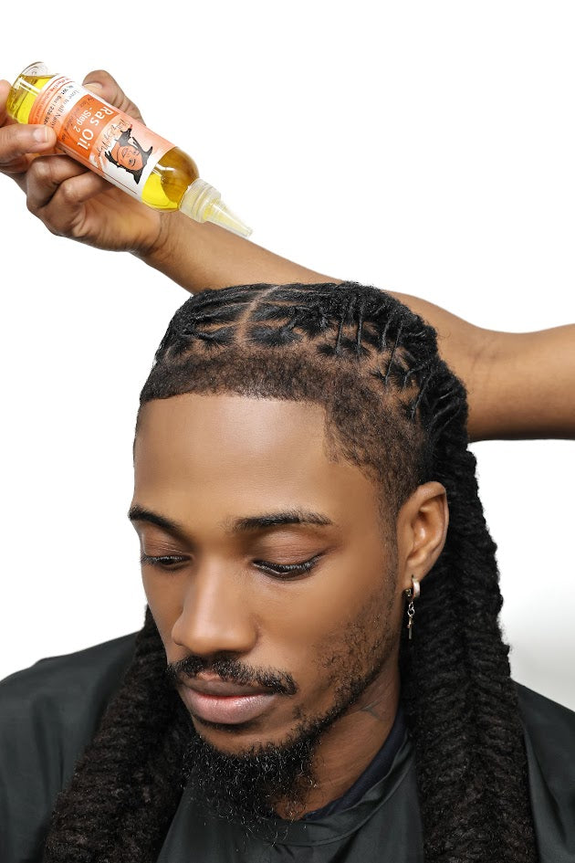 Black man with  styled long locs with woman holding a 4oz Natty By Nayee Corp Ras Oil- Step 2 over his head.
